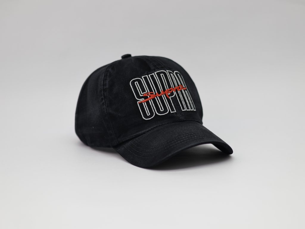 Boné preto com marca bordada, resultado da confecção de bonés personalizados feita na fábrica